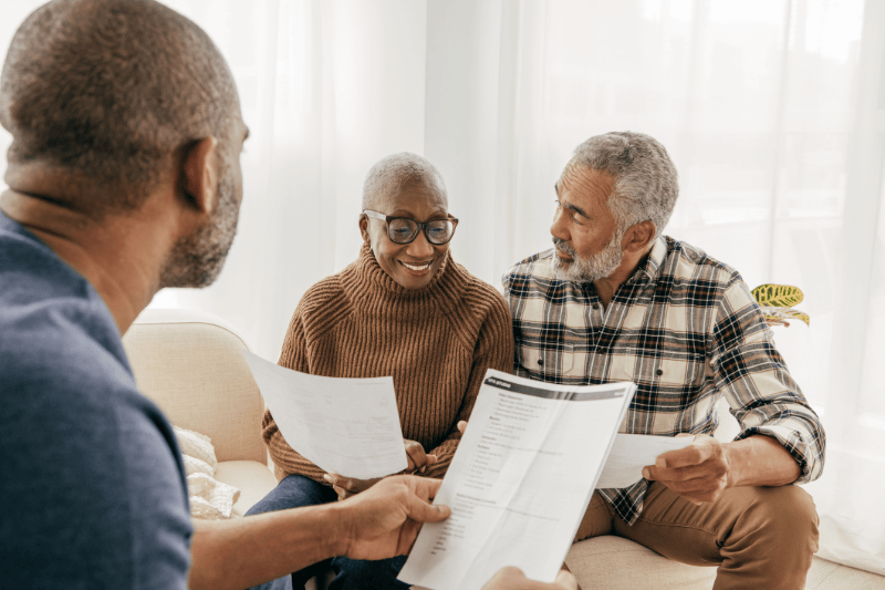 Agent meeting with senior couple to review Medicare options.